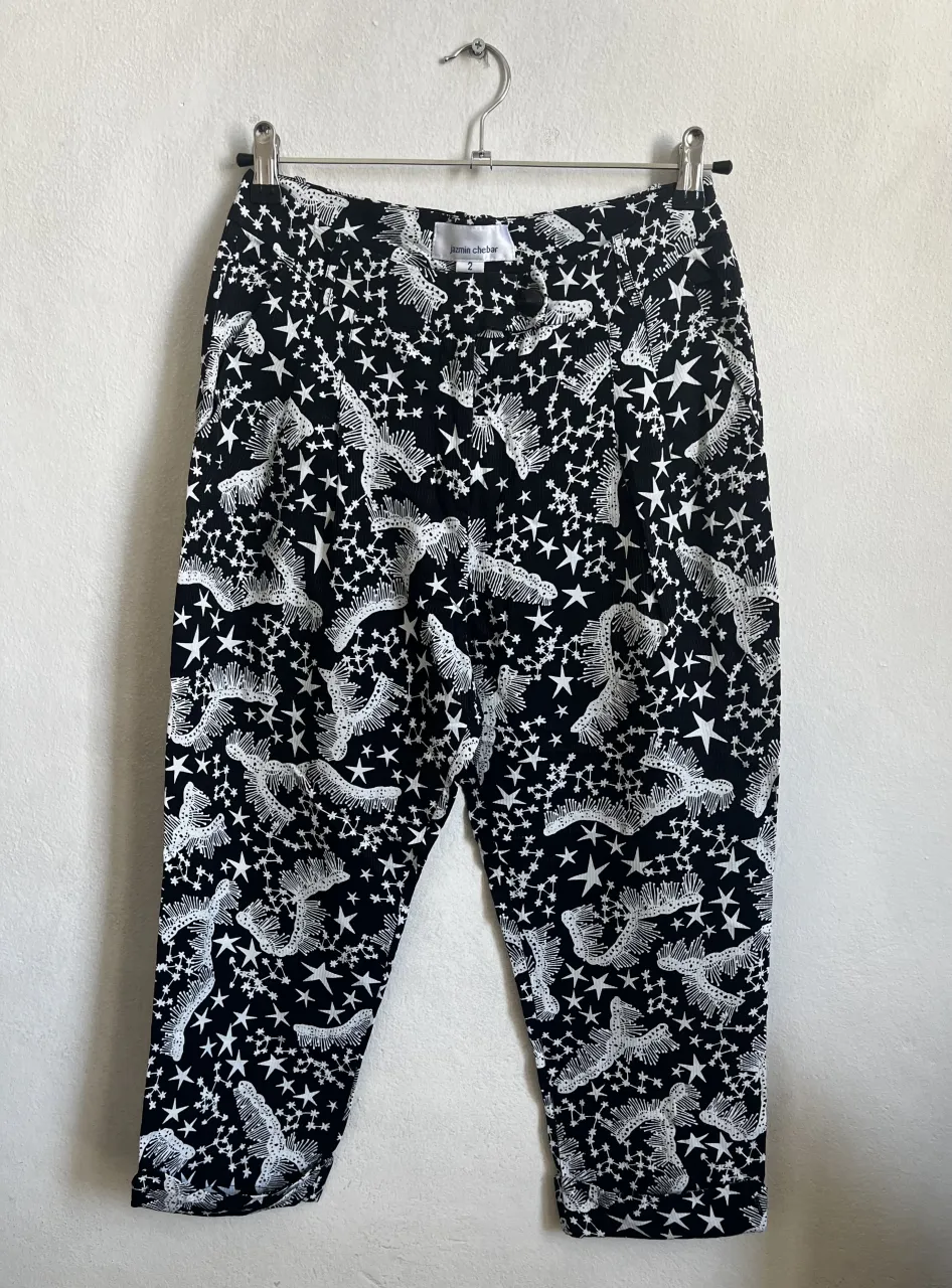 Pantalón estampado con diseño de estrellas y figuras abstractas en blanco y negro. Corte capri, ideal para un look moderno y canchero. Perfecto para combinar con remeras básicas o tops.