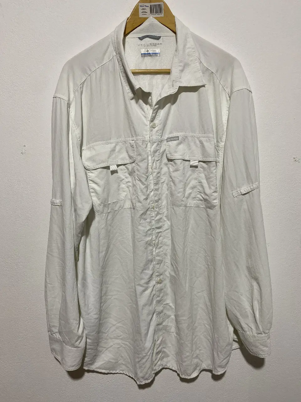 Camisa Columbia blanca de hombre, manga larga, con dos bolsillos delanteros y protección solar Omni-Shade. Ideal para actividades al aire libre.