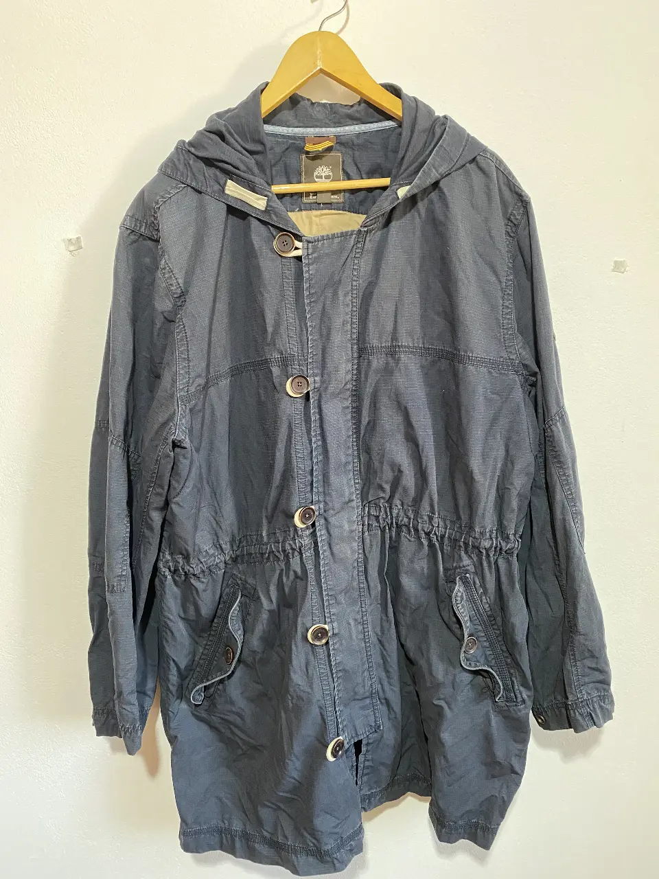 Campera Parka Timberland Earthkeepers azul oscuro con capucha, cierre con botones y ojales de hilo, ajuste en la cintura. Ideal para un look casual y cómodo. abrigo de media estación.