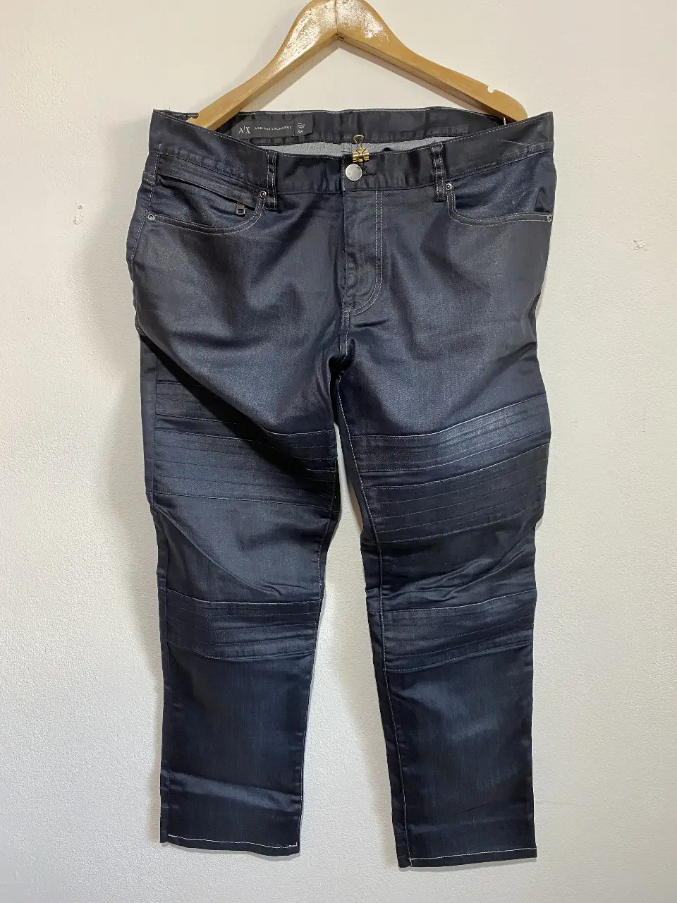 Jeans de hombre Armani Exchange, color azul oscuro con detalles en las rodillas. Bolsillo trasero con cierre a cremallera Talle 38. Ideal para un look casual y moderno.