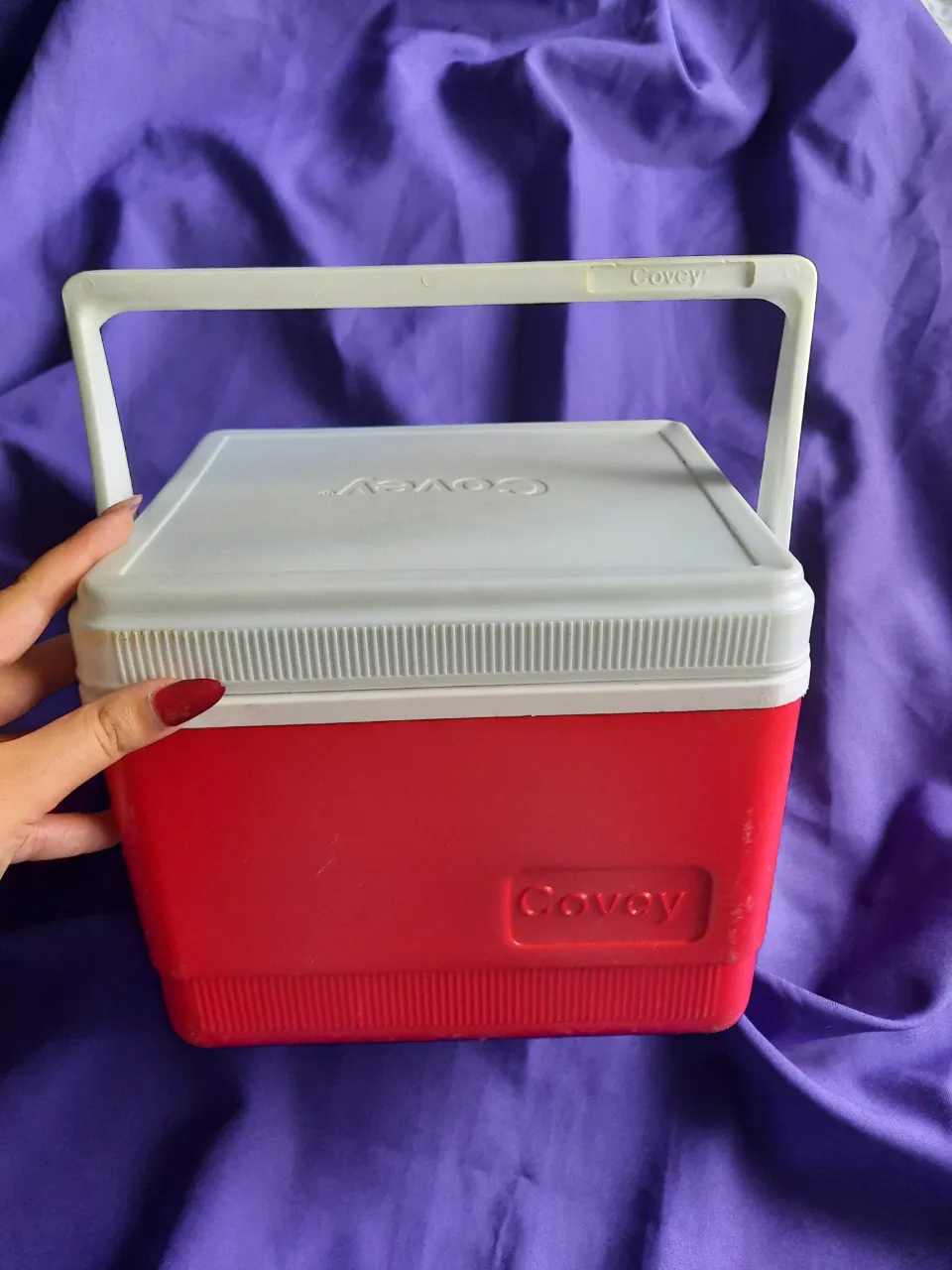 Conservadora de alimentos marca Covey, color rojo y blanco, con manija plegable. Ideal para llevar tus comidas o bebidas frías. Tipo heladerita para la playa.