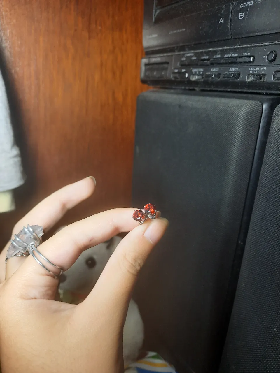 Par de aros pequeños con piedras rojas tipo brillos redondo, de acero quirúrgico. 