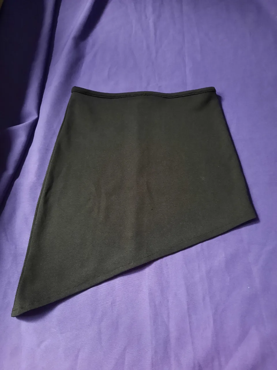 Pollera negra asimétrica con costura central en la parte trasera.