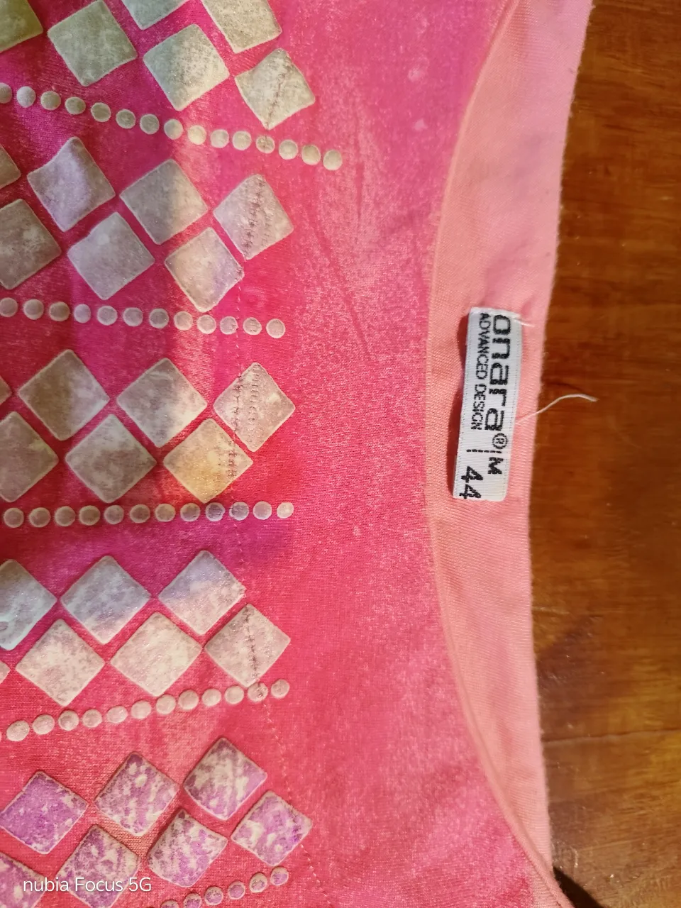 Remera manga corta con estampa de rombos y puntos en degradé de colores plateados y blancos. Posee un cuello redondo y mangas amplias.