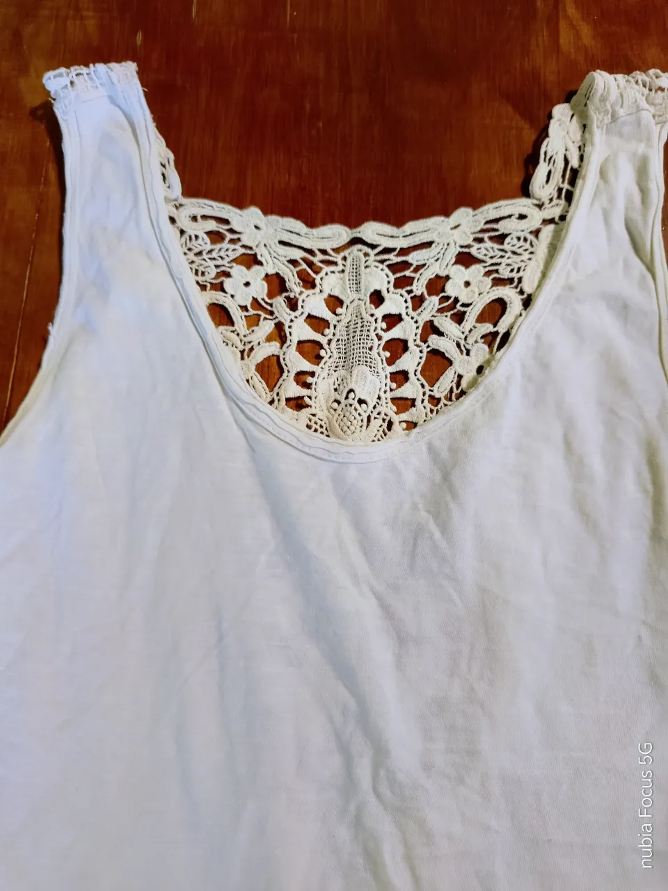 Musculosa blanca con detalle de encaje en la espalda y en los breteles.