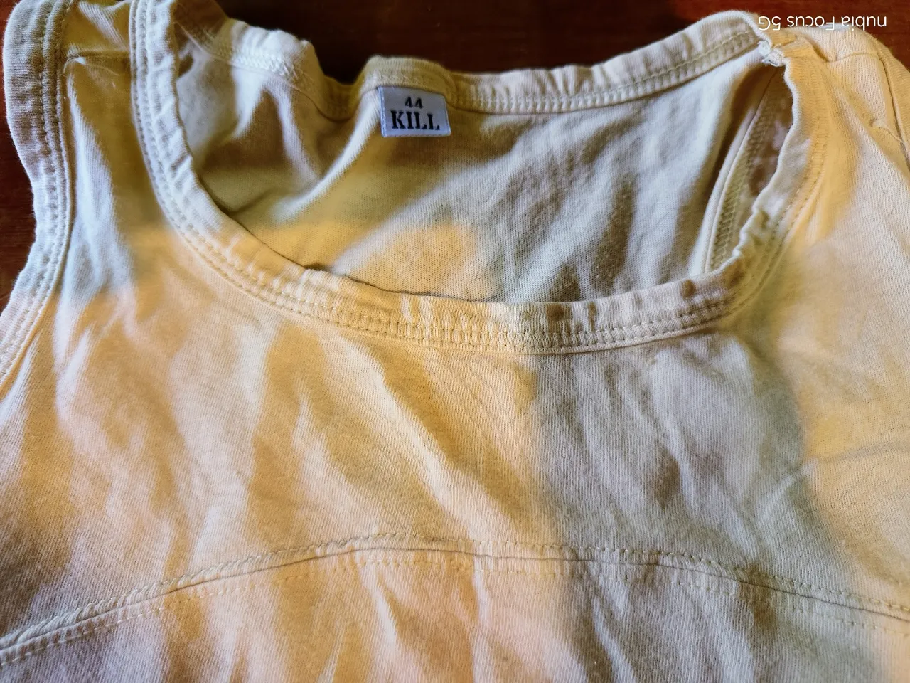 Musculosa de color amarillo pálido. Tiene costuras reforzadas en el cuello y en la parte superior delantera.