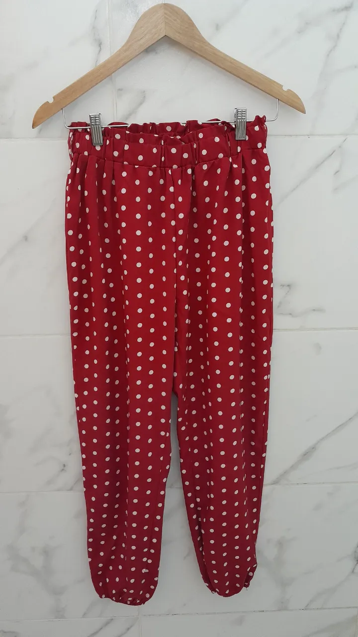 Pantalón rojo con lunares blancos y elástico en la cintura.