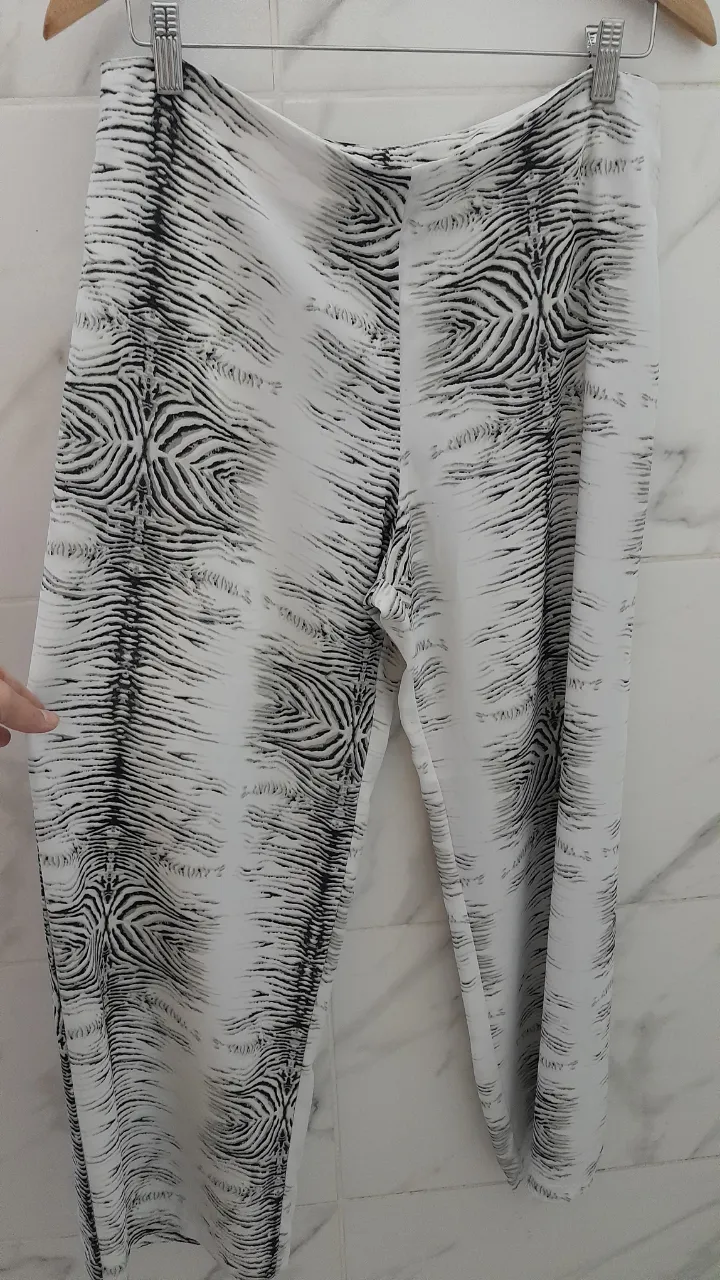 Pantalón blanco con estampa abstracta en negro. Cierre lateral.