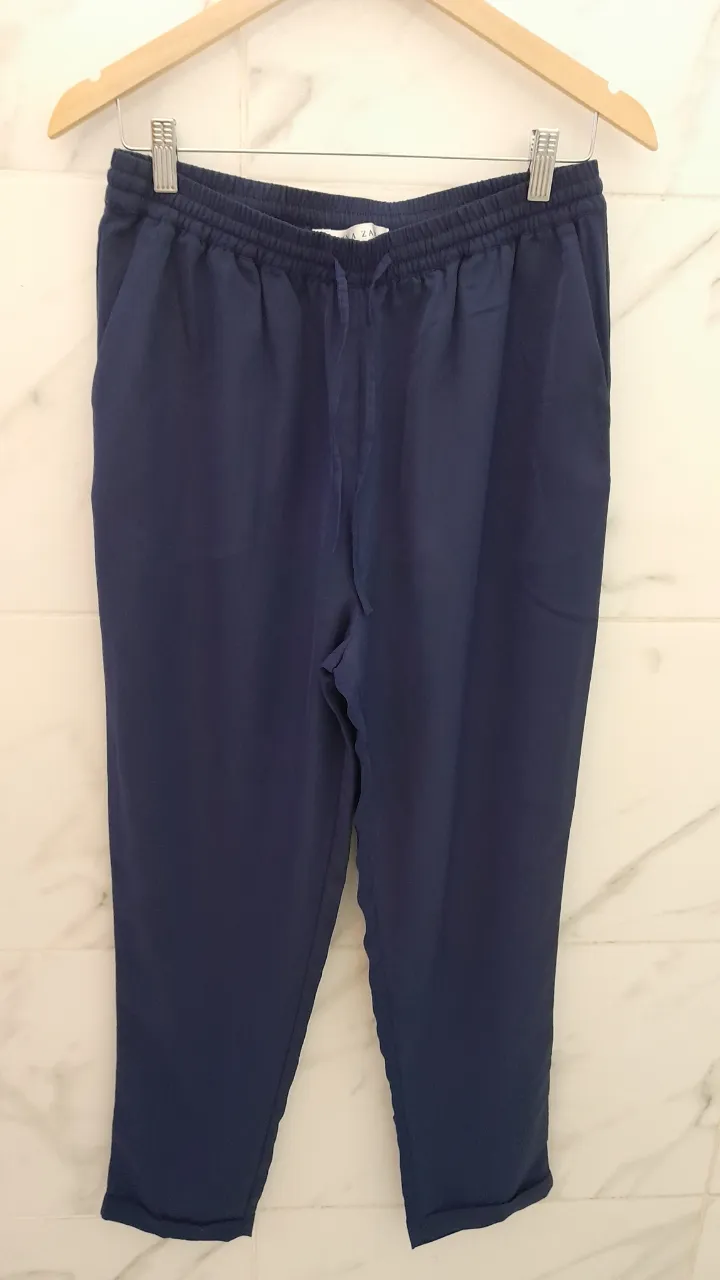 Pantalón de color azul marino con cintura elastizada y cordón de ajuste. Posee bolsillos laterales.