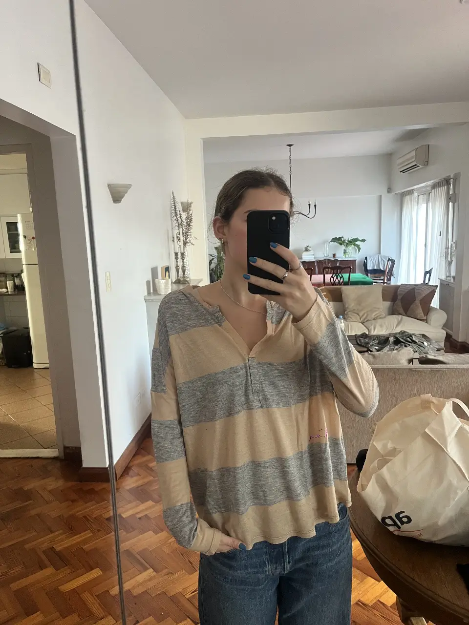 Remera de manga larga a rayas horizontales en tonos gris y crudo. Cuello en V con detalle de botones. Marca Desiderata.