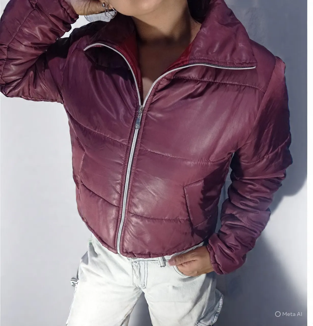 Campera acolchada corta de color bordo con cierre metálico al frente y cuello alto. Posee bolsillos laterales.