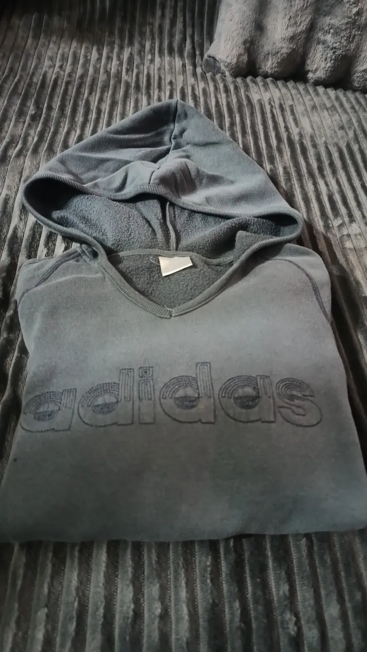 Buzo gris con capucha y bolsillo canguro. Estampa del logo de la marca en el frente.