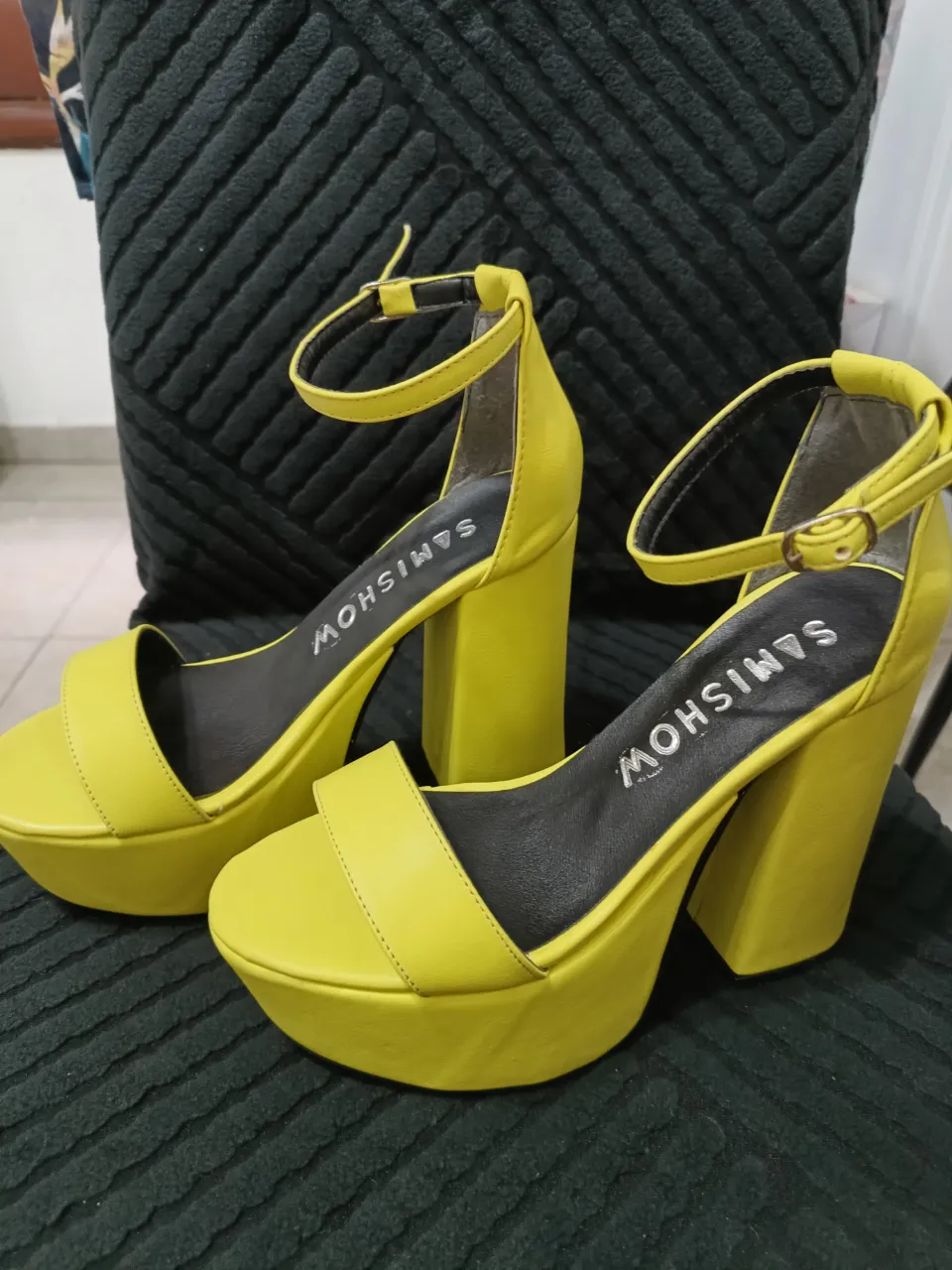 Sandalias amarillas con plataforma y taco grueso. Tienen una tira en el empeine y una pulsera con hebilla en el tobillo. La marca 'SAMISHOW' está impresa en la plantilla.