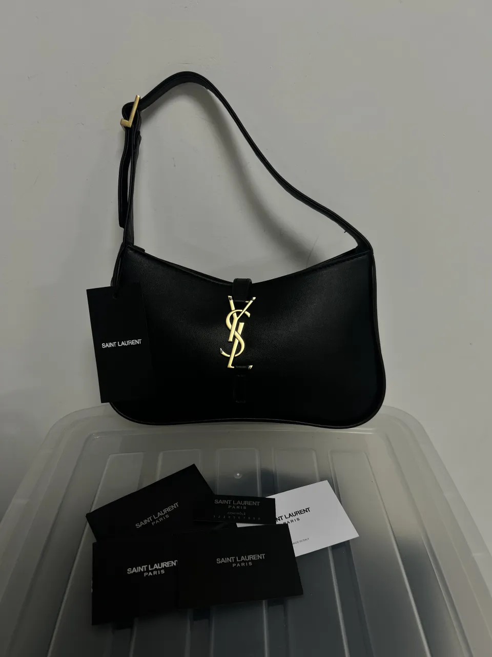 Cartera con logo dorado de Yves Saint Laurent. Correa ajustable con hebilla dorada. Interior forrado con bolsillo con cierre.