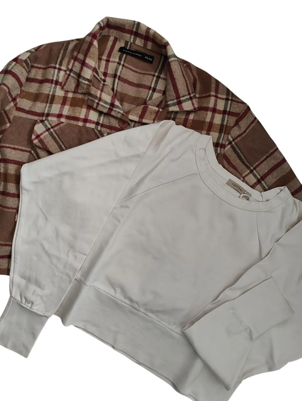 Las 2 prendas : Saco Cuesta Blanca, estilo leñador a cuadros en tonos marrones y rojos. Posee dos bolsillos en el frente con tapa y botones. Cuello camisero y mangas largas con puño.
Más buzo cenizas, color crudo talle L.