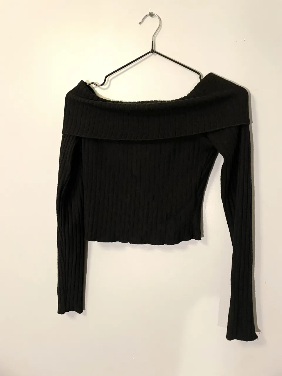 Top negro escotado con mangas largas, ideal para un look canchero y moderno. Su diseño off-shoulder lo hace súper sensual y perfecto para salidas nocturnas o eventos informales.