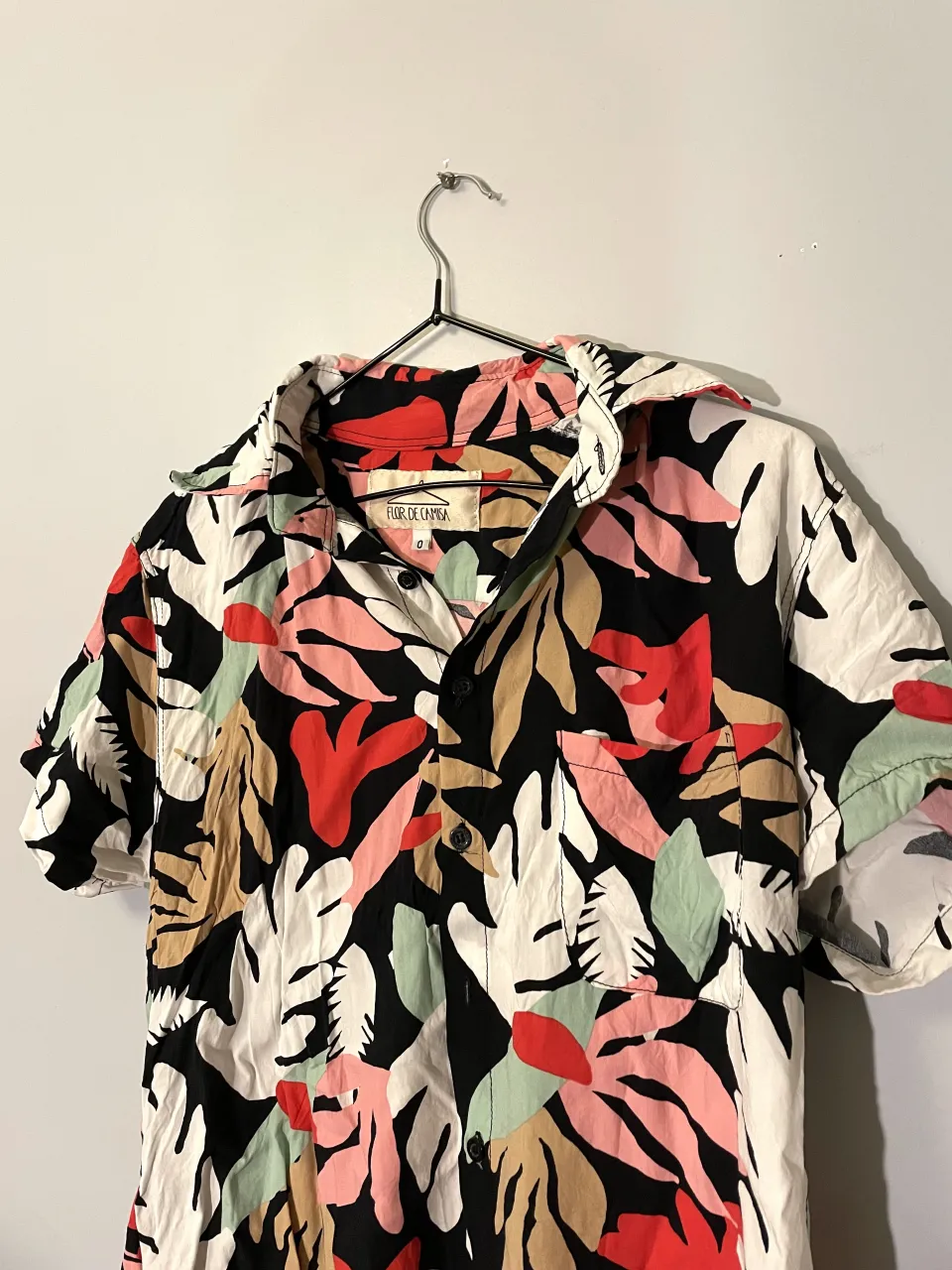 Camisa de manga corta con estampa floral vibrante. Ideal para un look relajado y canchero en días de sol. Combina con shorts o jeans para un outfit de verano.