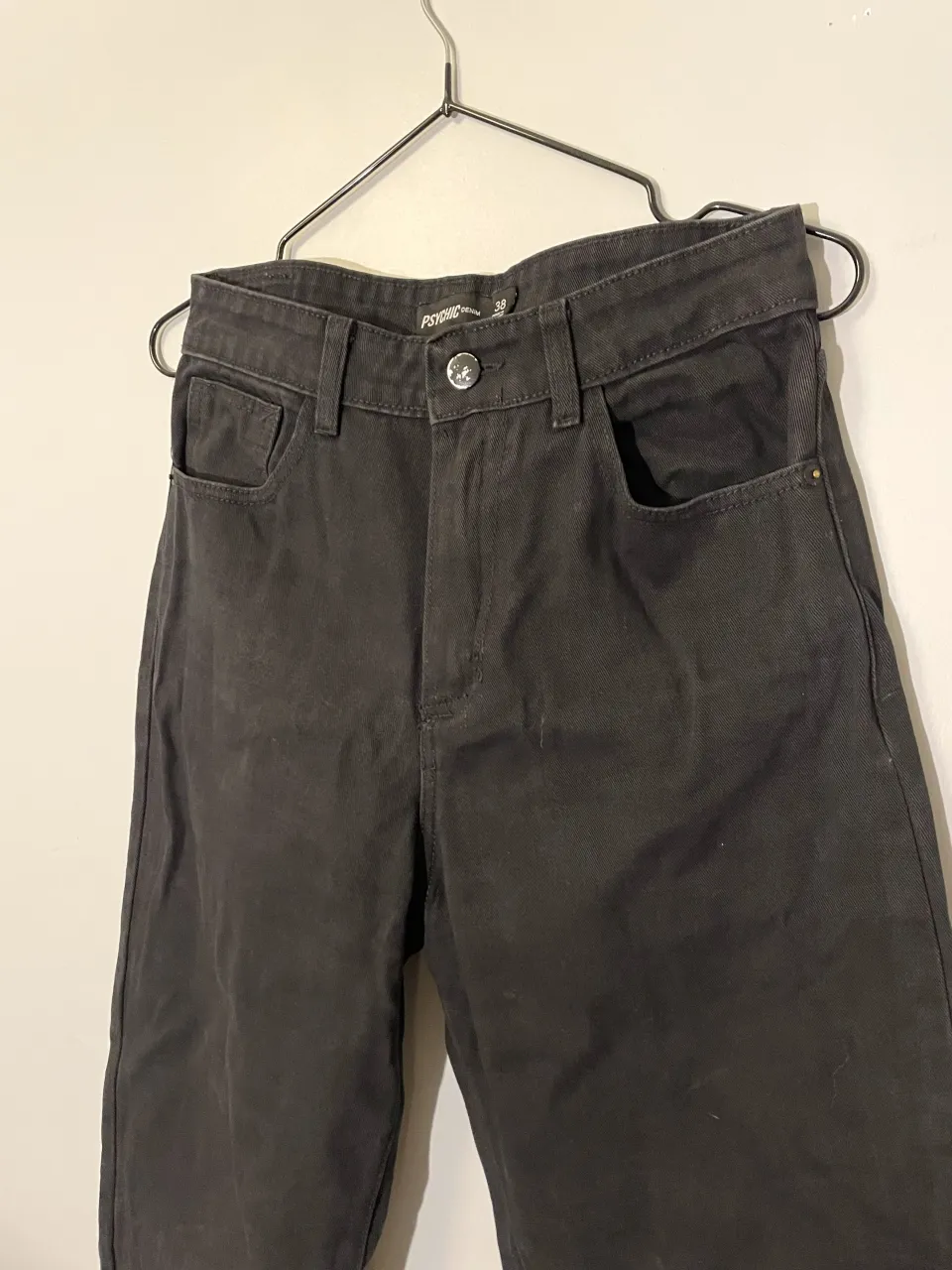 Jeans negros tiro alto, corte recto y estilo casual. El botón está un poco despintado, todo lo demás en perfecto estado.