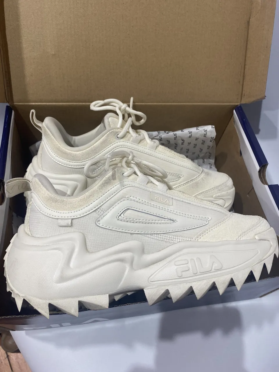 Zapatillas Fila Twister color beige, ideales para un look casual y moderno. Su diseño único con suela dentada las hace destacar.