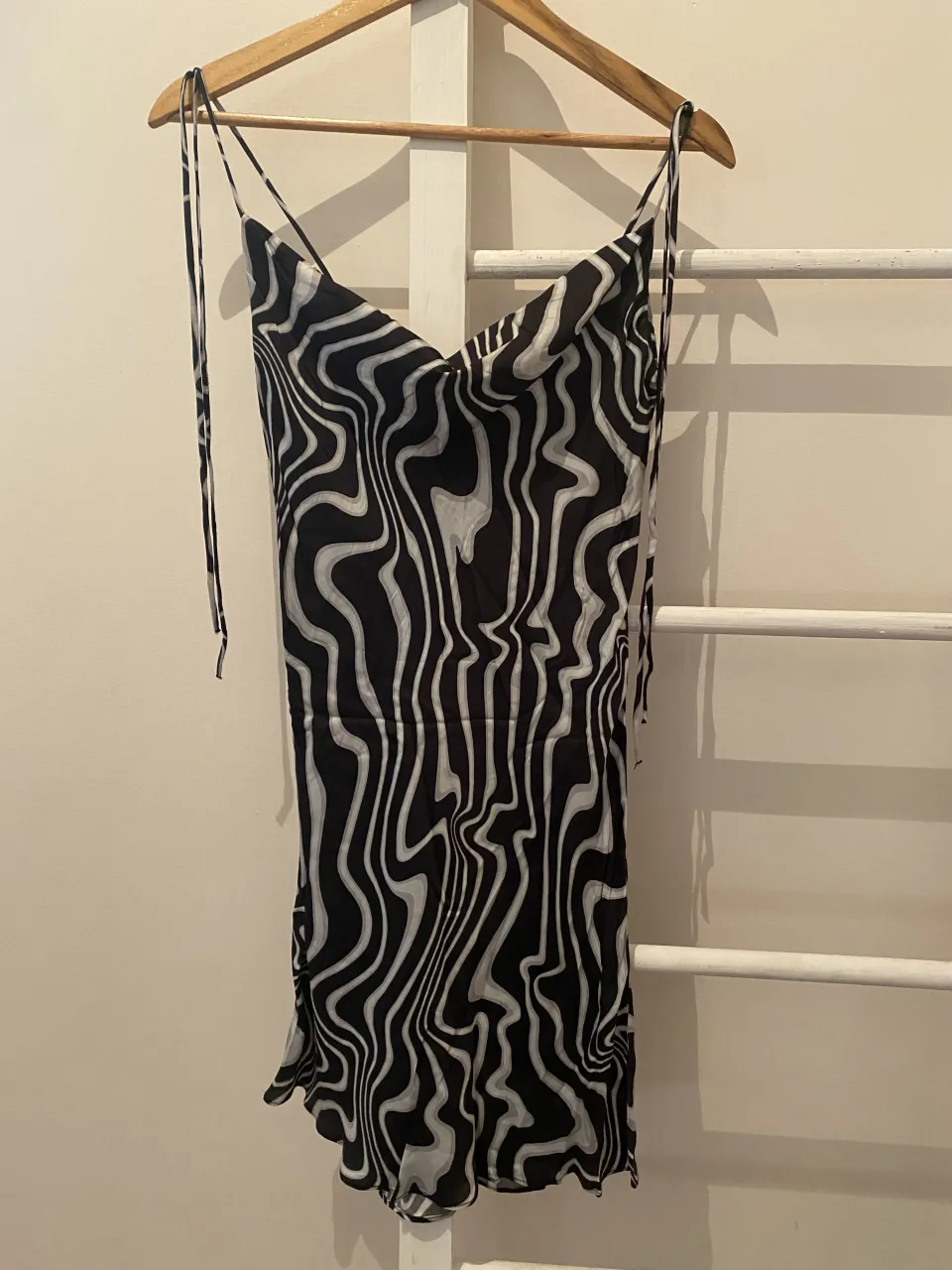 Vestido corto con estampado abstracto en blanco y negro. Breteles finos regulables.