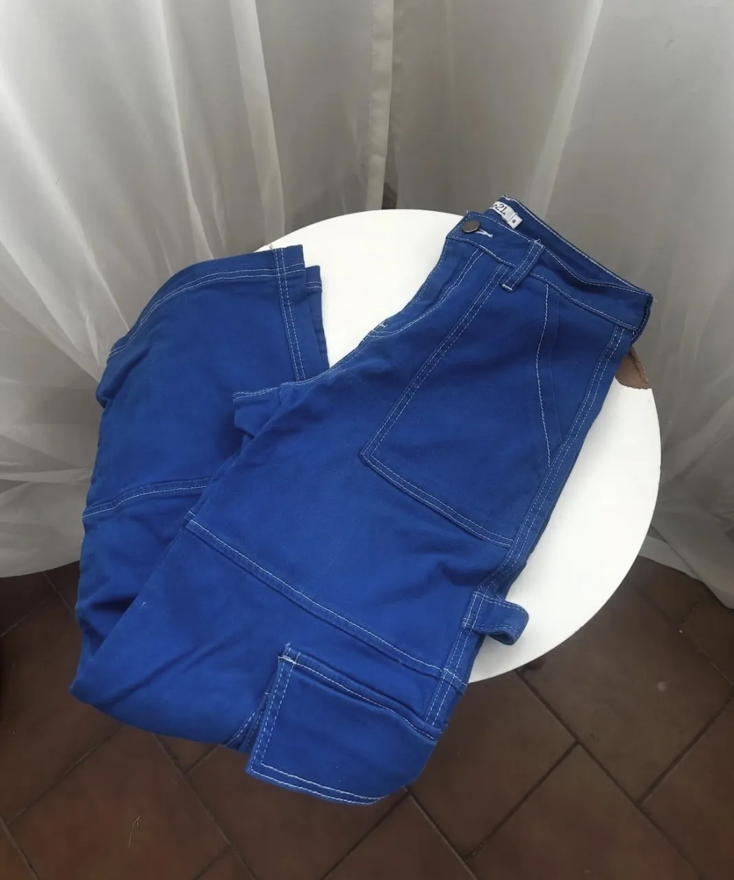 Pantalón cargo de gabardina azul con costuras blancas al contraste. Posee bolsillos cargo en los laterales y bolsillos plaqué en la parte trasera.