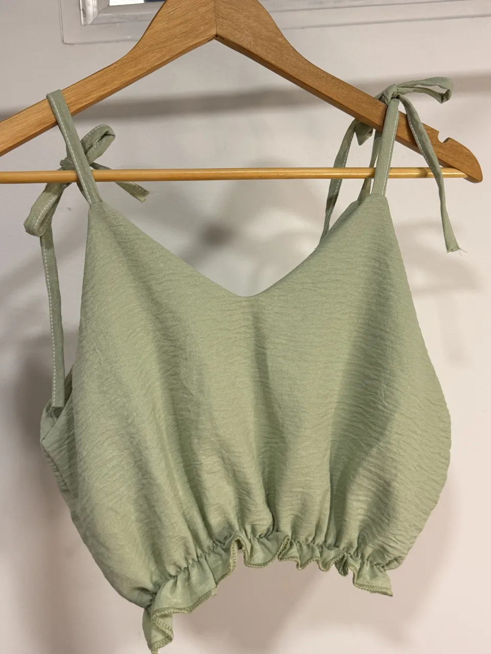 Top con brillos de tela liviana con breteles regulables y detalle de volados en el ruedo. Ideal para un look fresco y canchero.