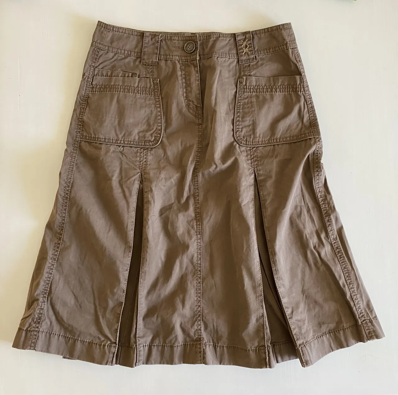 Pollera cargo color marrón. Tiene bolsillos cargo con tapa y botón en la parte delantera y trasera. Presenta detalles de pespuntes y pliegues verticales. Medidas: cintura 42cm, cadera 49cm, largo 62cm.
Perfecto tiro bajo para un talle 40/42