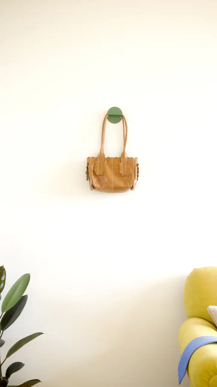 Cartera de mano de cuero marrón con detalles de diseño. Ideal para un look casual o para una salida.