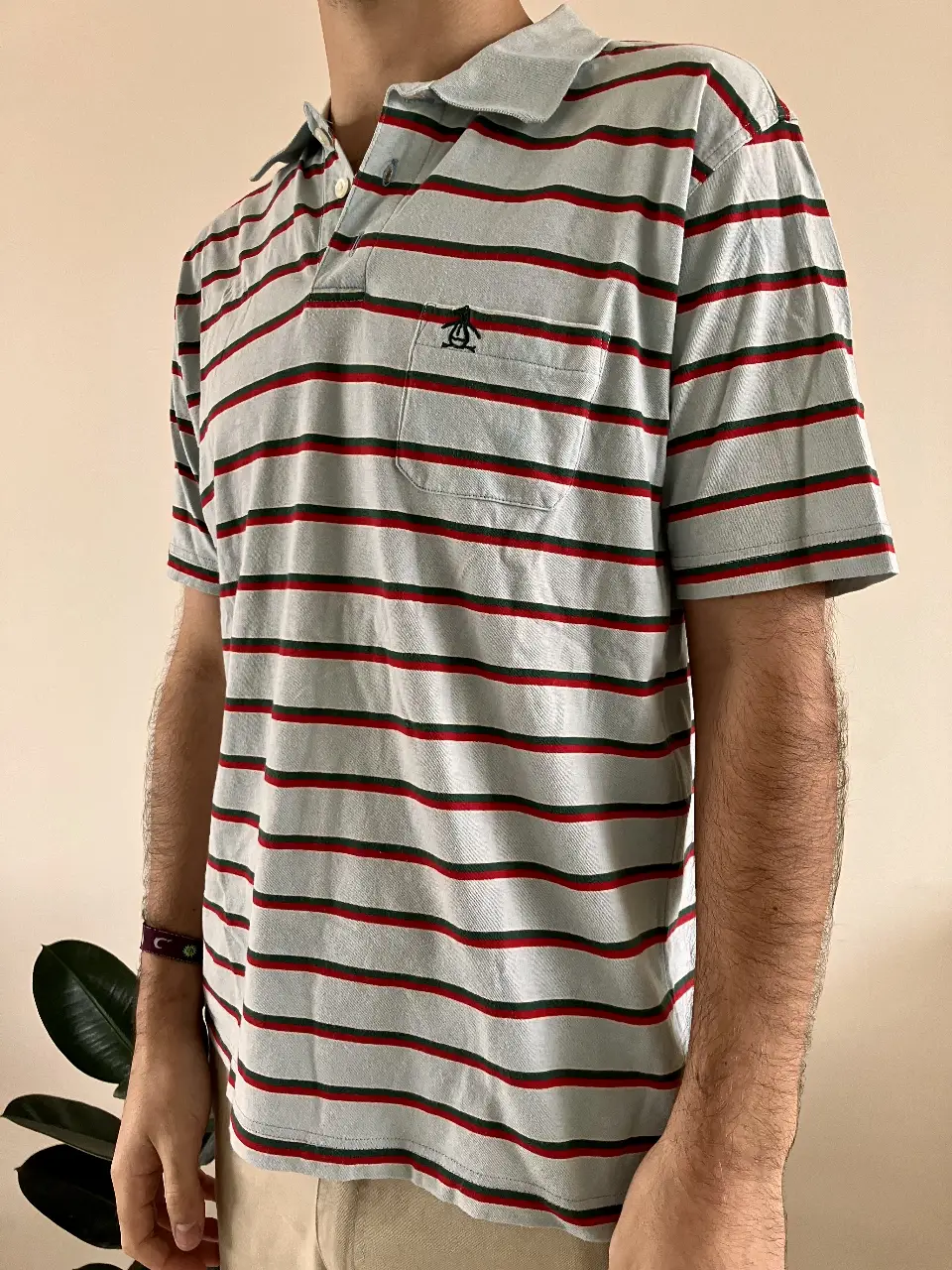 Remera polo de hombre, a rayas horizontales celestes, rojas y verdes. Con bolsillo en el pecho y logo de la marca. Ideal para un look casual y cómodo.