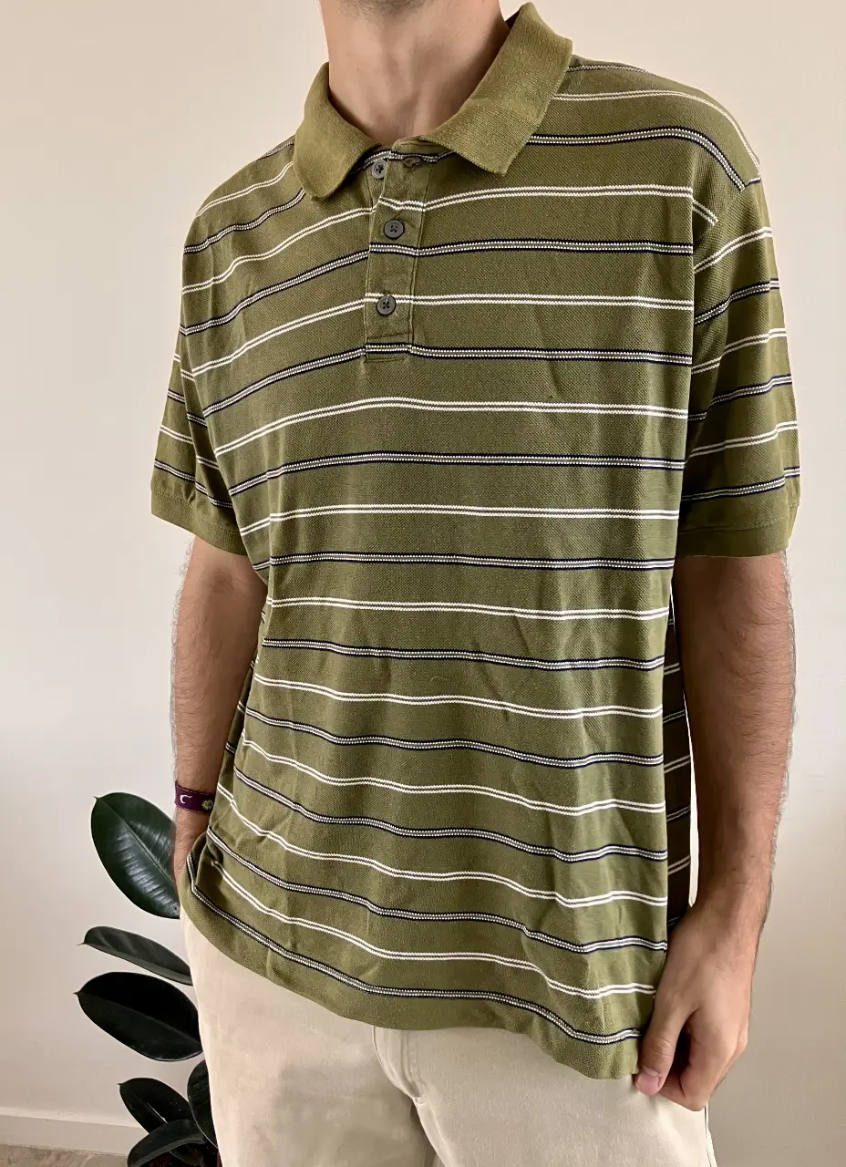 Remera polo de hombre a rayas horizontales en tonos verde oliva y blanco. Diseño clásico con cuello y botones, ideal para un look casual y cómodo.