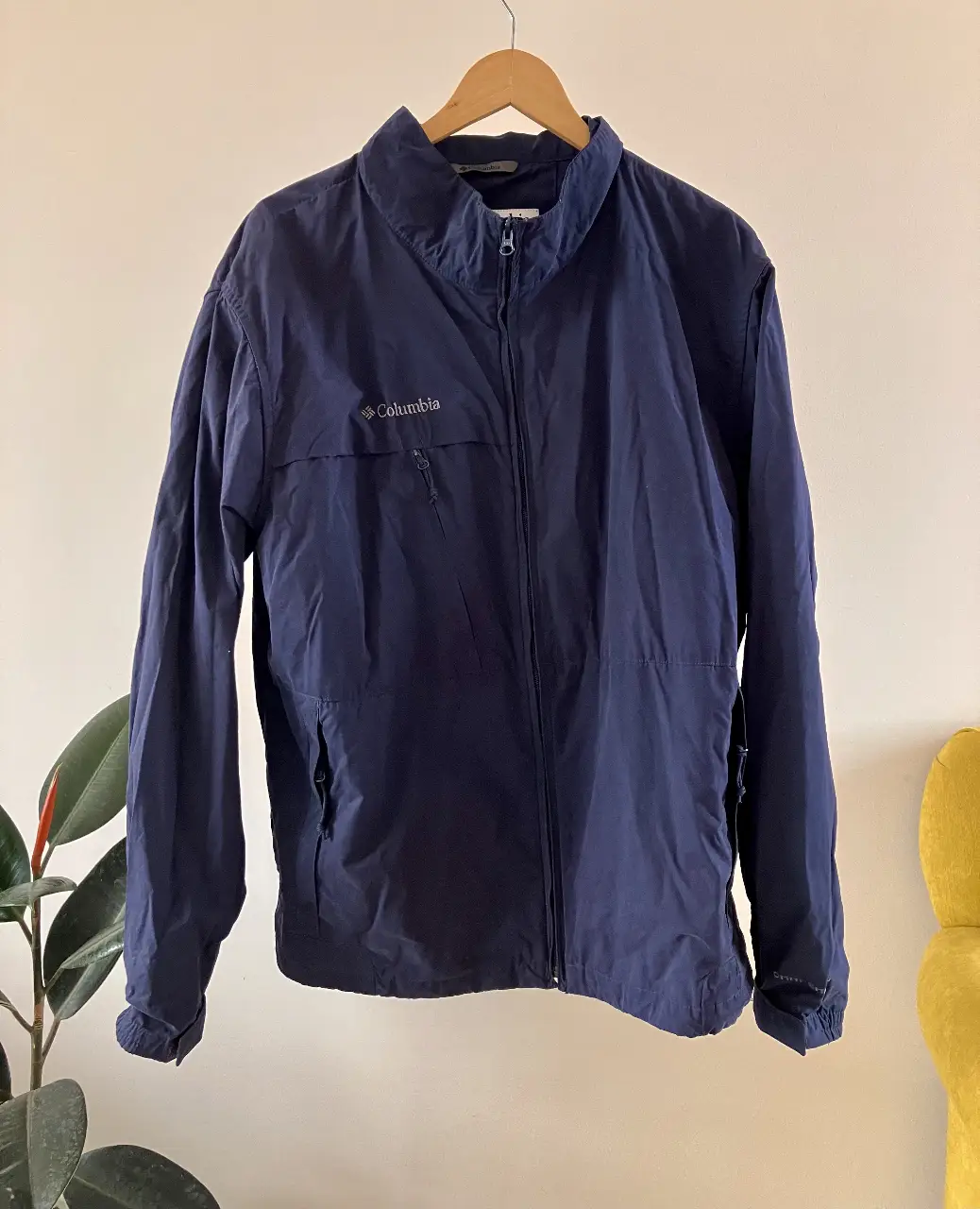 Campera rompe viento Columbia azul marino, con cierre y bolsillo frontal. Ideal para actividades al aire libre o uso diario. 