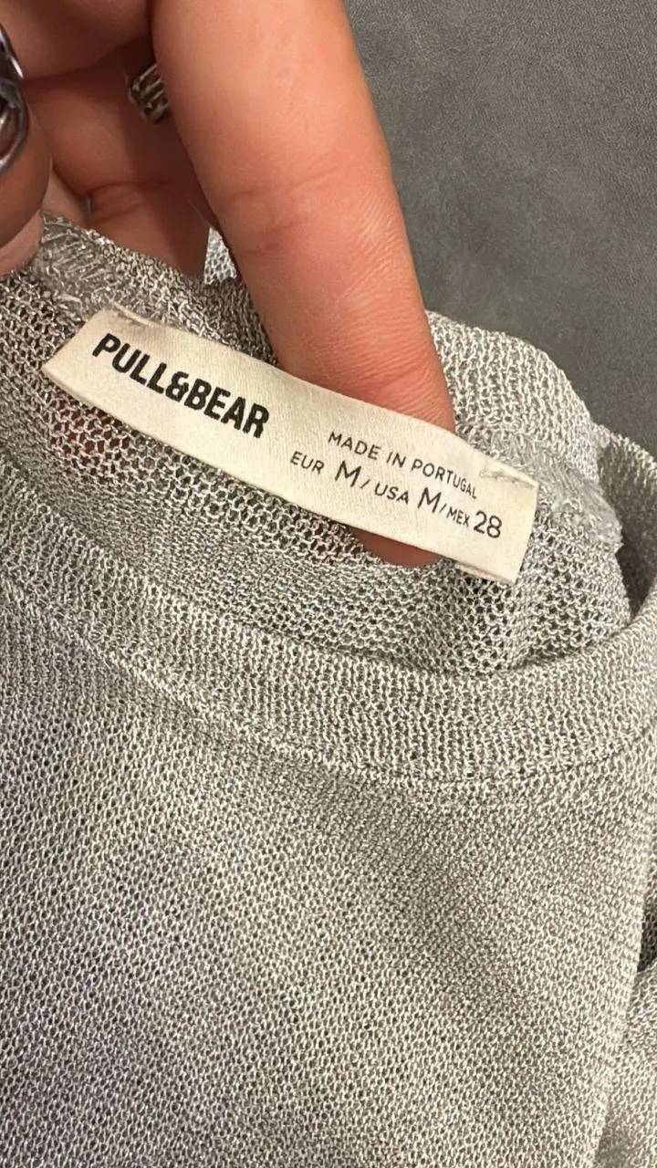 Remera manga larga de tejido metalizado plateado. Cuello redondo.