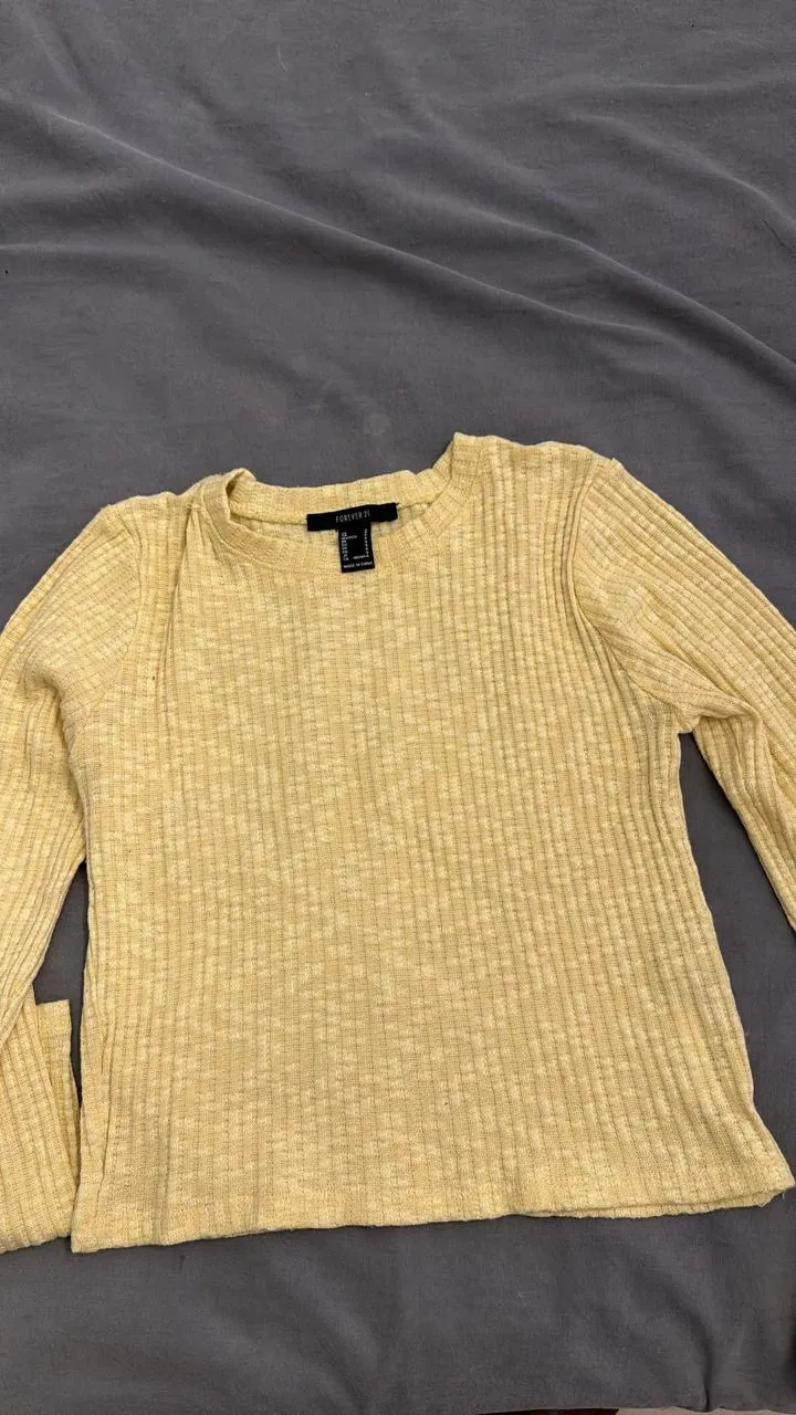 Remera amarilla de manga larga con textura acanalada.