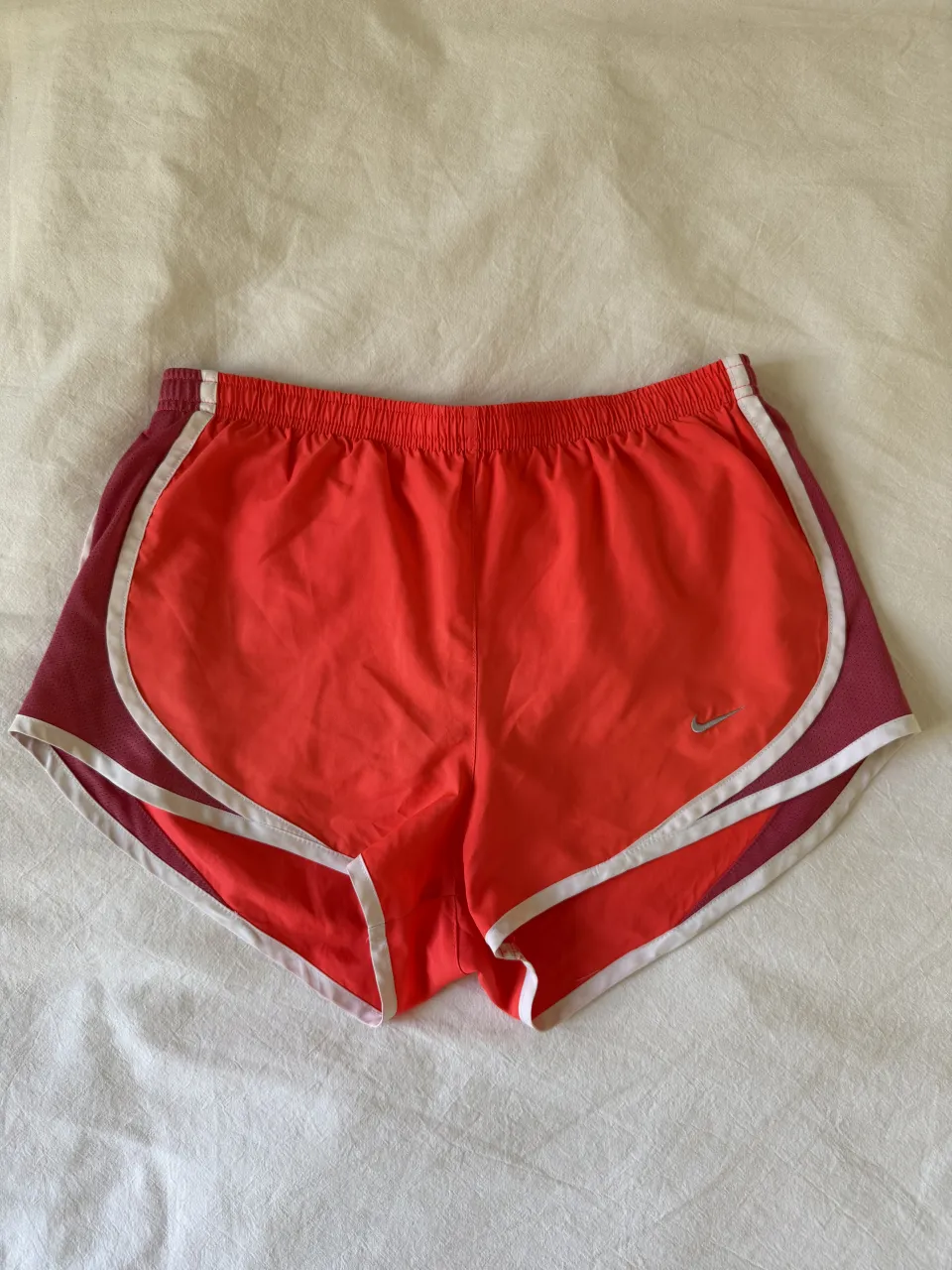 Shorts deportivos con bombachudo de color naranja con detalles en color bordó y blanco. Cintura elástica.