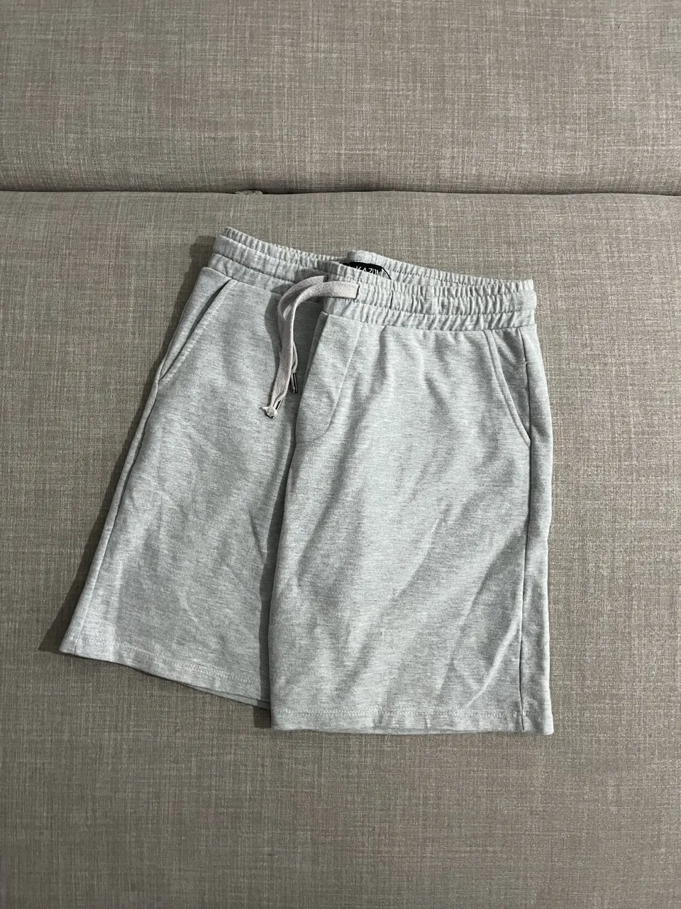 Shorts de algodón gris con cordón ajustable en la cintura y bolsillos laterales. bastante ajustado a pesar de ser L.