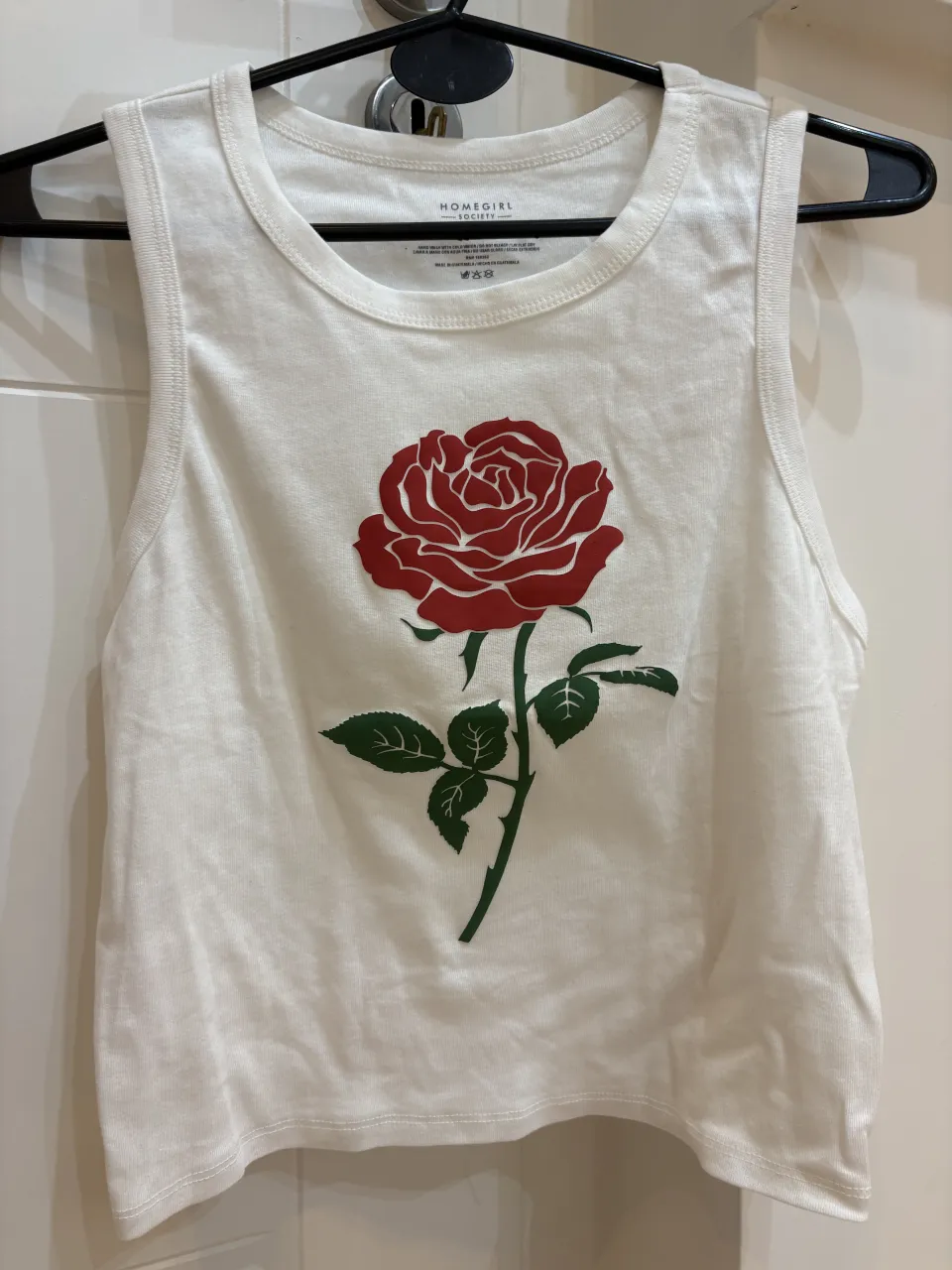 Musculosa blanca con estampa de rosa roja y hojas verdes.