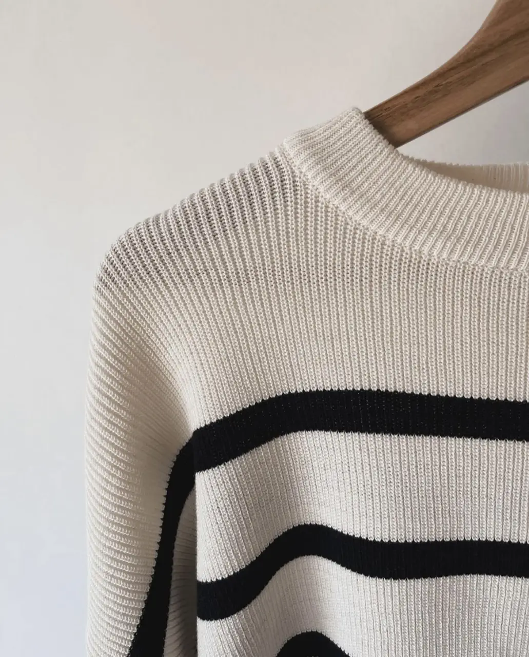 Sweater de punto a rayas horizontales en color blanco y negro. Cuello redondo y mangas largas. Ideal para un look casual y moderno.