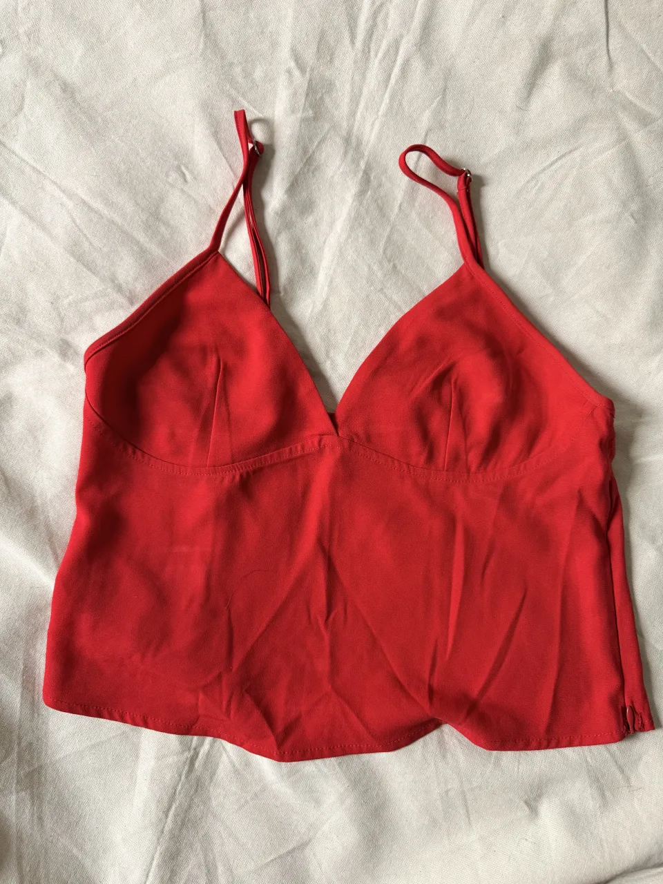 Top rojo con tiras finas y escote en V de Kosiuko.
tiene algunos detalles de su uso. (foto)