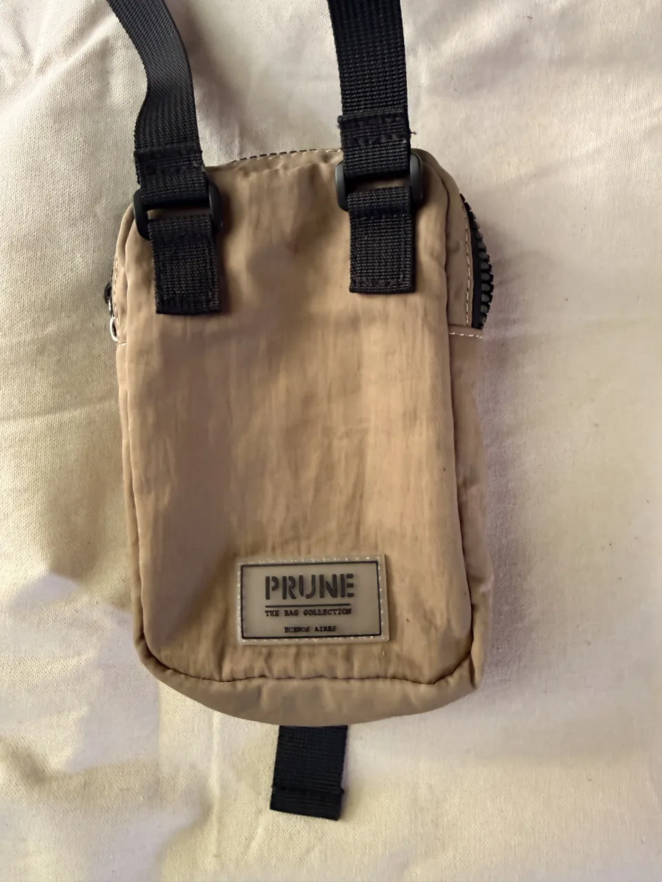 Portacelular Prune color beige. Nuevo sin etiqueta, prácticamente no está usado. medidas aproximadas 
18cm alto 
12cm ancho 
3cm profundidad 