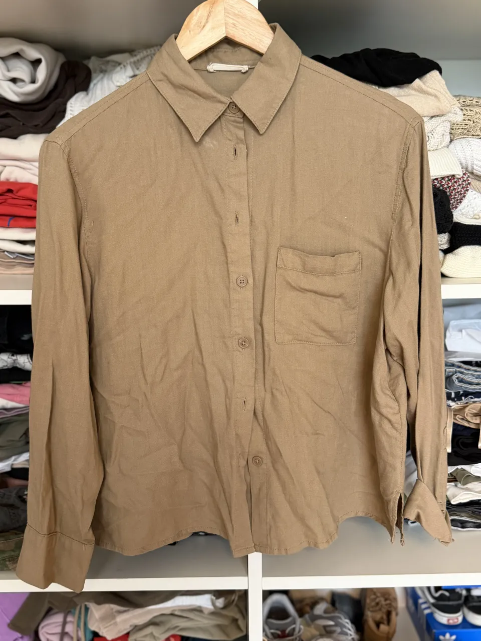 Camisa de manga larga color tiza con botones al frente y un bolsillo en el pecho.