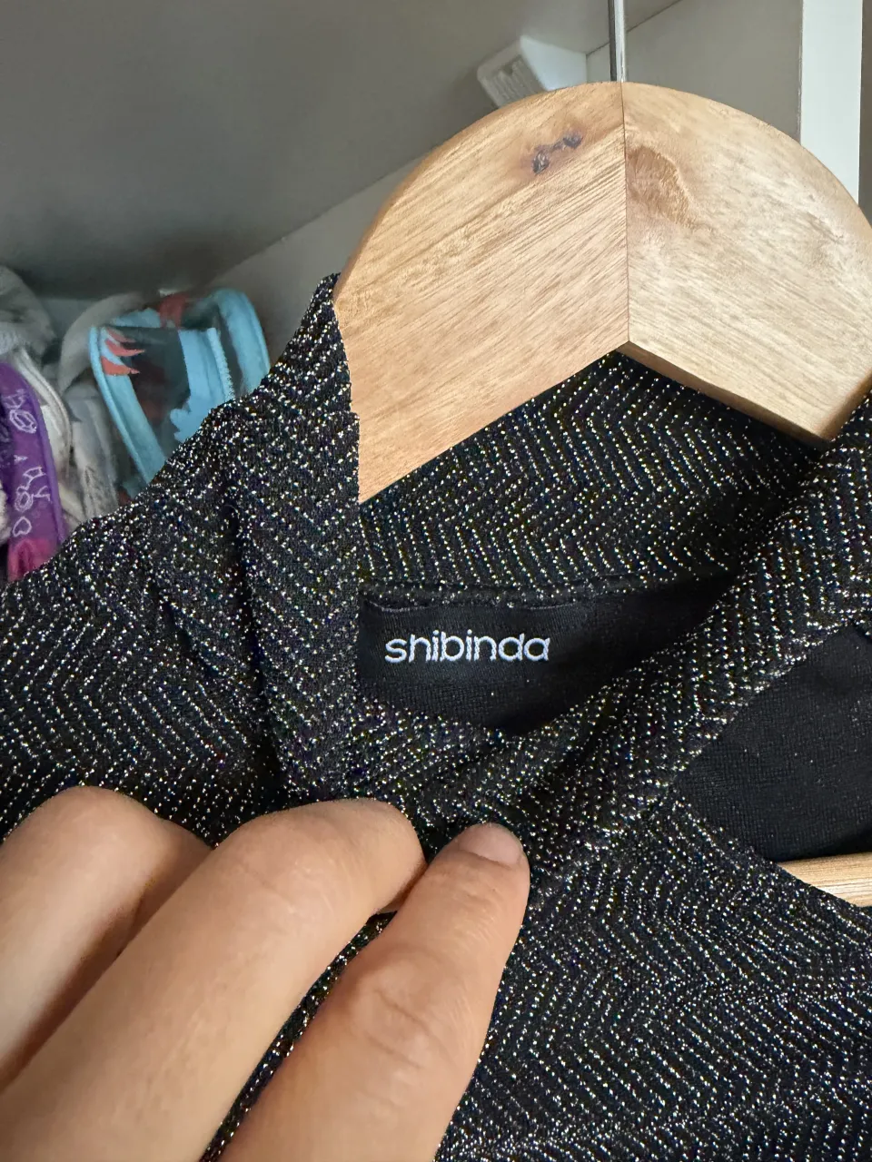 Remera manga larga negra con cuello alto y un corte asimétrico en el hombro. Posee un tejido con brillos sutiles en forma de espiga.