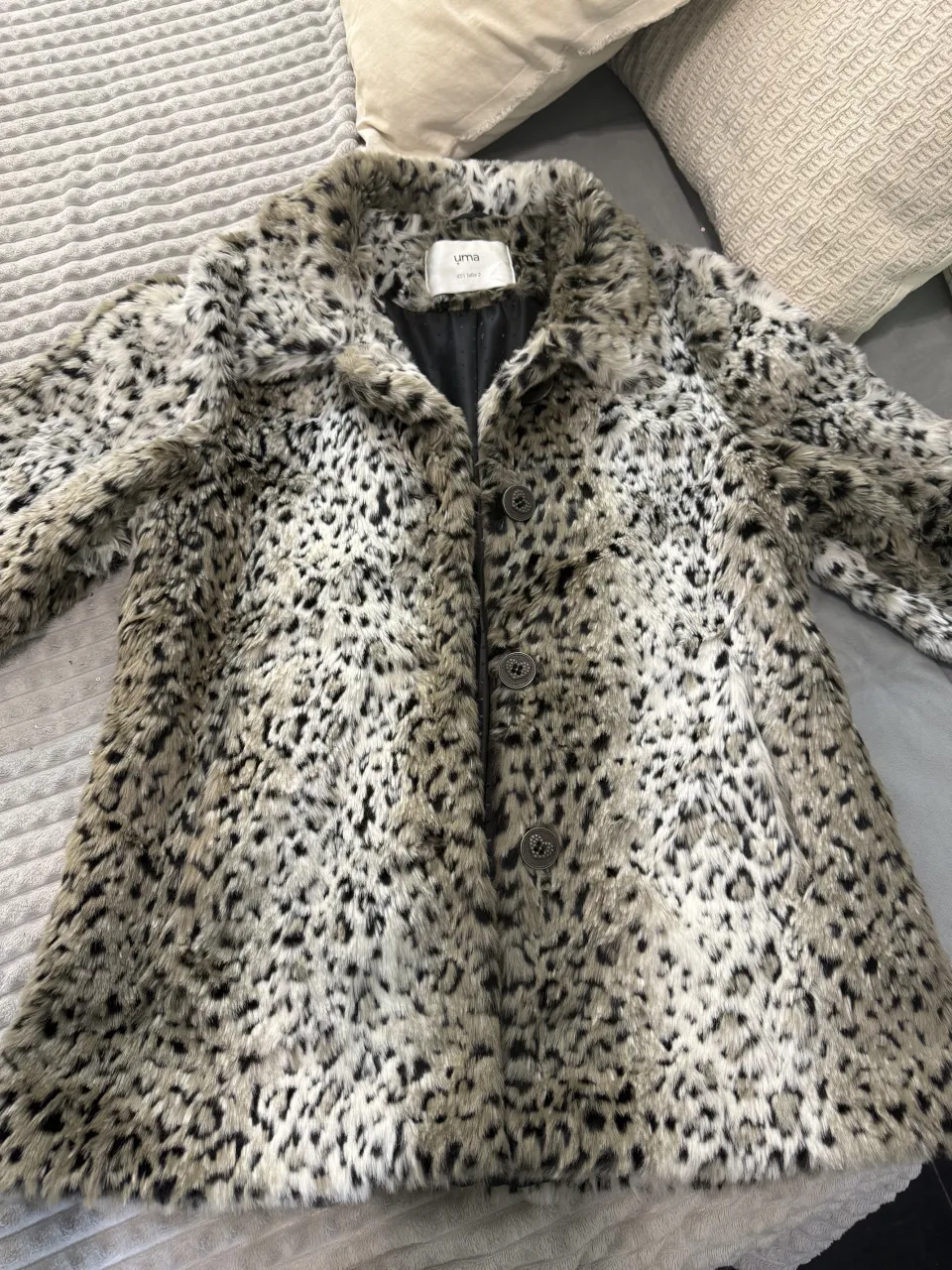 Campera de pelo sintético con estampa animal print. Posee cuello solapa y cierre de botones al frente. Dos bolsillos laterales.