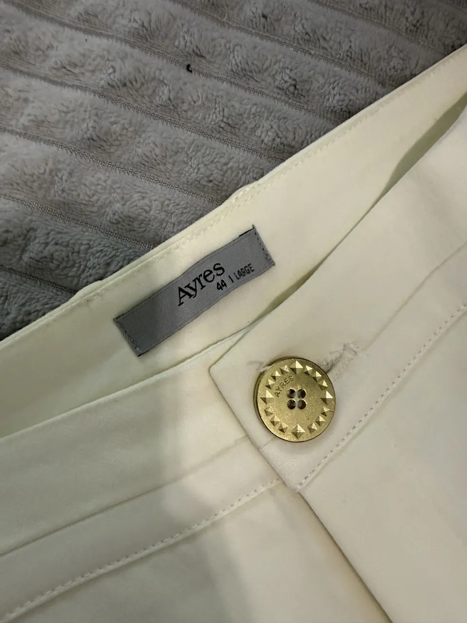 Pantalón liso color crema con un botón dorado en la cintura. tiro medio 
cintura 40 cm 
tiro delantero 26 cm 
tiro trasero 35 cm 
largo total achupinado 97 cm 