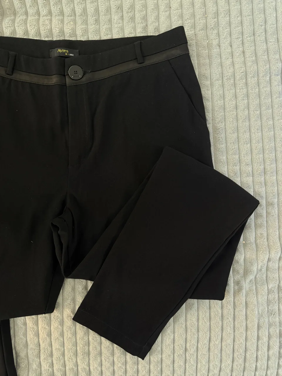 Pantalón negro con detalles de cinta satinada en la cintura y un botón al frente. Tiro medio
cintura 39 cm 
tiro delantero 26 cm 
tiro trasero 35 cm 
largo total 95 cm 