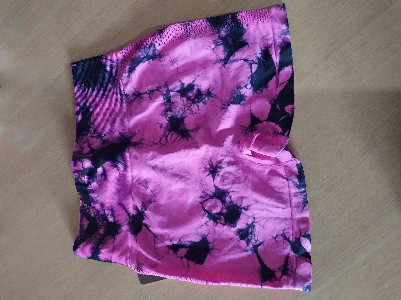 Short deportivo de mujer con estampado tie dye en tonos rosa y negro. Ideal para actividades físicas.