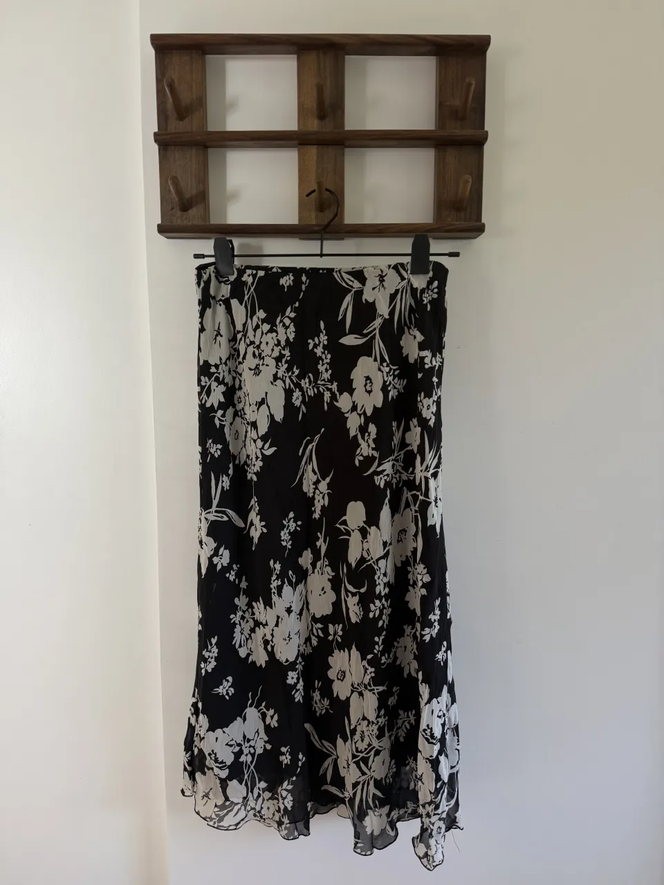 Pollera vintage midi estampada con flores blancas sobre fondo negro. Posee un volado en la parte inferior. Liviana, cómoda y con calce súper lindo. Ideal para verano o media estación, y para un look de día o de noche. 