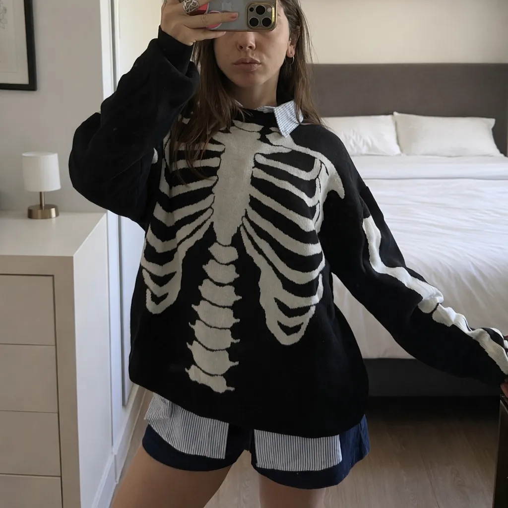 Sweater oversized negro con estampa de esqueleto blanco en el frente. Cuello redondo y mangas largas. Ideal para un look canchero y diferente.