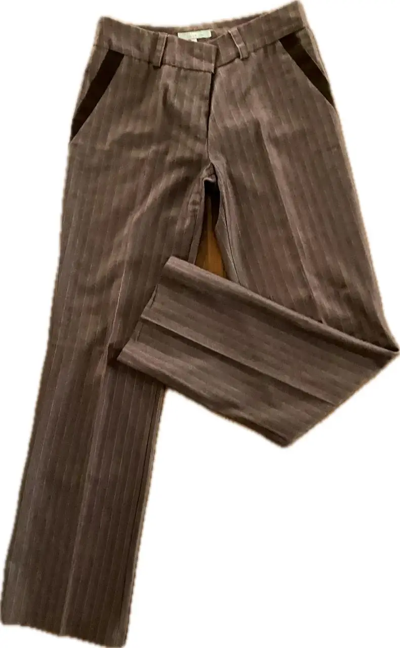 Pantalón sastrero de mujer, color marrón con rayas verticales. Posee detalles en color marrón oscuro en los bolsillos y cintura. Talle S.