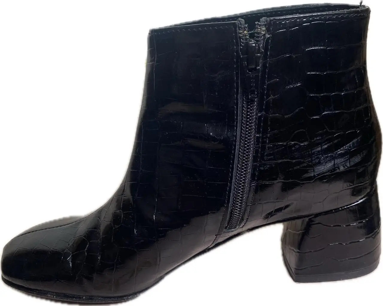 Botas de cuero sintético con diseño de cocodrilo. Tienen cierre lateral para facilitar el calce y un taco ancho que proporciona estabilidad y comodidad.