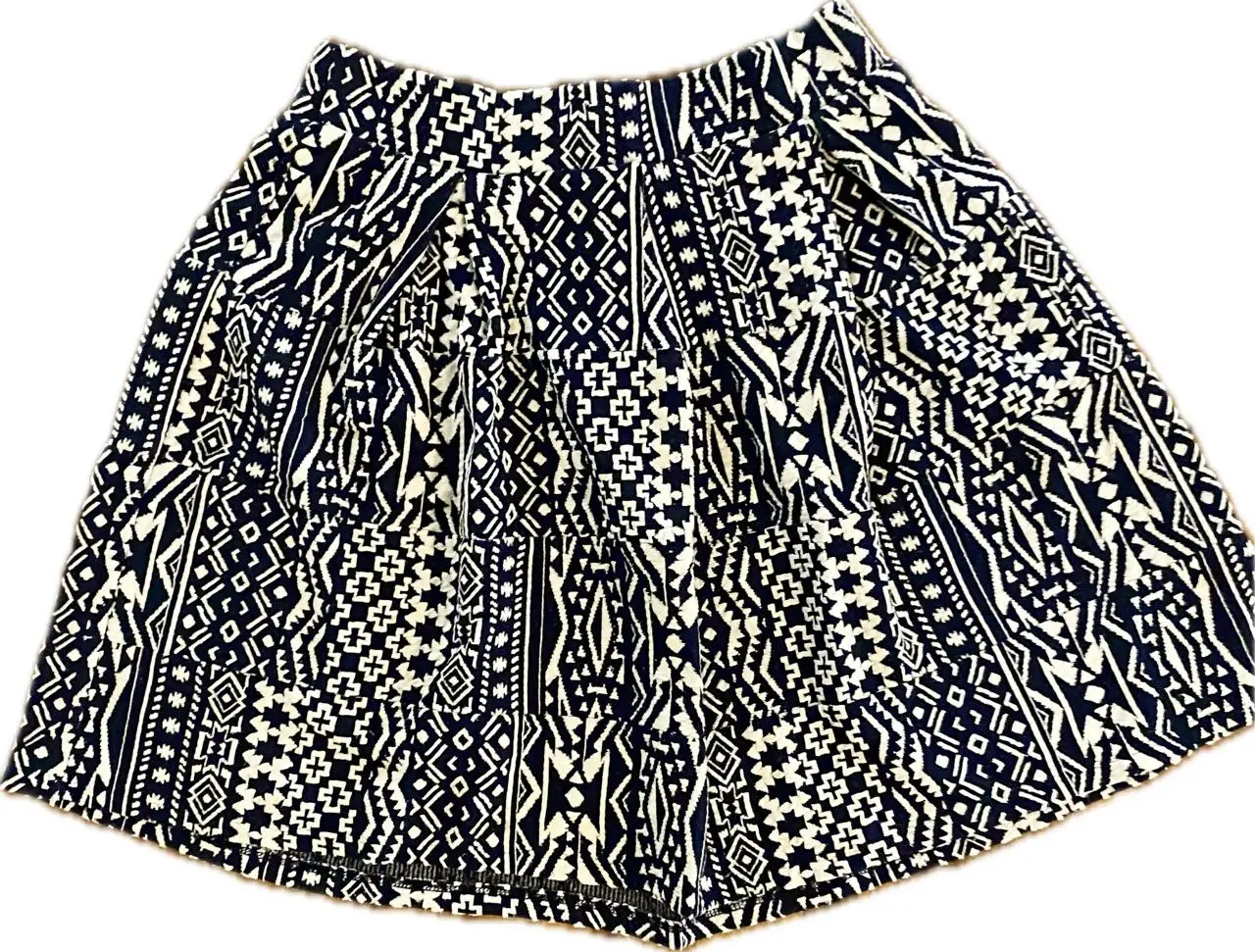 Pollera  con estampado geométrico en blanco y azul, tiro alto y corte holgado. Ideal para un look fresco y cómodo.